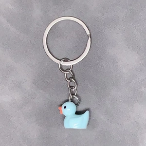 Minimalist light blue resin duck keychain with silver ring on a neutral background