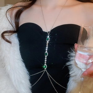 Detail view of crystal fringe body chain with emerald gemstones and gold tassels