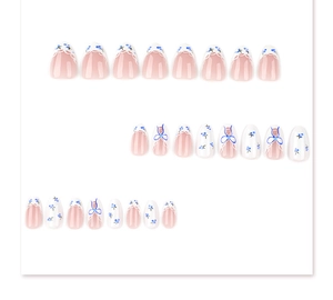 Detail view of 24pcs almond press-on nails with blue floral patterns and bow designs