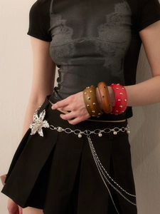 Detail of vintage wooden bangles with metal studs and silver floral waist chain belt