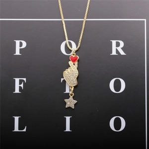 Gold necklace with heart-hand gesture pendant, red heart and star charm on black card