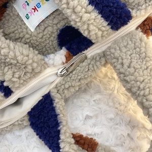 Détail macro du sac en sherpa pelucheux à pois avec fermeture éclair et étiquette zakka