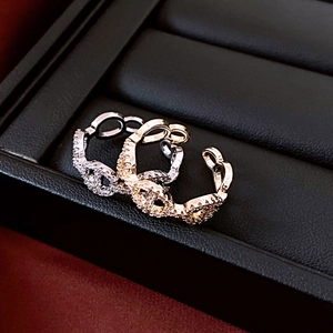 Macro shot of 14K gold and silver plated double C rings with zircon stones in a gift box