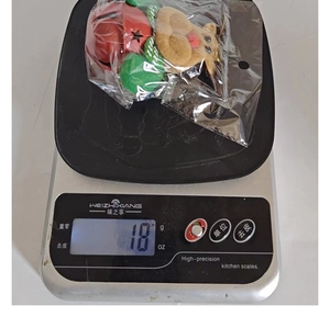Detailed view of lightweight 18g Christmas reindeer bell ornament on a digital scale