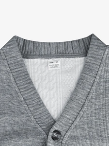 Détail du col d'un cardigan gris en maille avec étiquette de taille et matière
