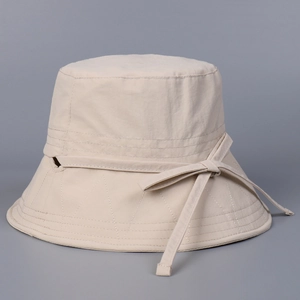 Détails d'un chapeau de soleil beige en nylon avec coutures ondulées et ruban