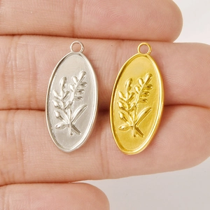 Macro shot of oval 304 stainless steel floral pendants in gold and silver finishes