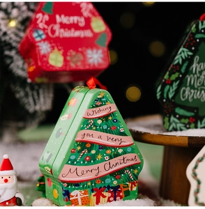 Detail of Christmas tree shaped tin box with holiday greeting and festive decorations