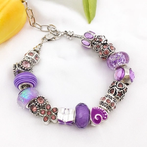Detailed view of a purple beaded bracelet with crystal charms and heart enamel beads
