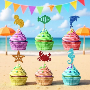 Glittery ocean animal cupcake toppers for a mermaid theme party on a sunny beach setting