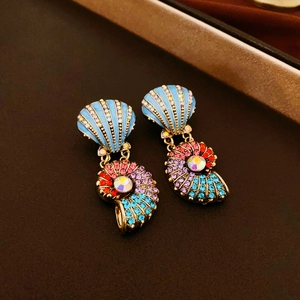 Detailed close-up of shell-shaped earrings with colorful rhinestones and blue enamel