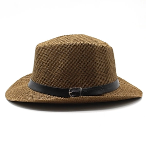 Detailed macro view of dark brown woven straw texture and black leather strap with silver buckle