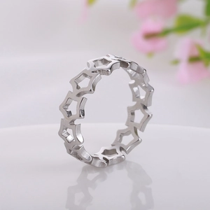 Detailed view of silver titanium steel ring with hollow star cutouts on reflective surface