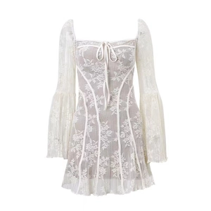 Dettaglio dell'abito mini in pizzo bianco con scollo quadrato e lacci sul davanti