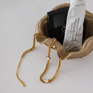 Gros plan sur un collier gourmette en acier inoxydable doré 18K avec zircons cubiques