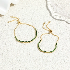 Detail of adjustable gold-plated bracelets featuring round green cubic zirconia stones