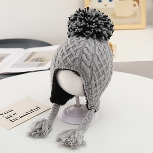 Close-up of winter knit hat featuring gray cable patterns and soft faux fur lining