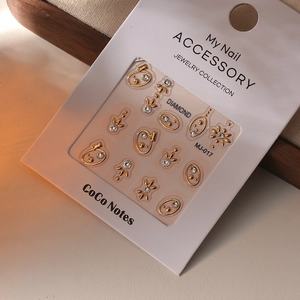 Dettaglio di charms per unghie dorati con cristalli su scheda prodotto MJ-017