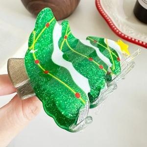 Sparkly green Christmas tree hair claw clip with festive star and wave patterns
