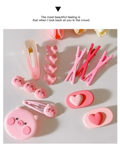 Flat lay of pink Y2K hair clips including cute pig and heart designs on white surface