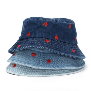 Close-up of three shades of denim bucket hats featuring red heart embroidery patterns