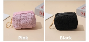 Detail of pink and black waffle textured mini coin purses with golden key rings
