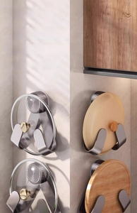 U-shaped stainless steel wall mount pot lid rack holding various glass and ceramic covers