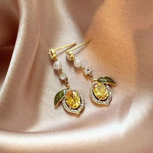 Exquisite gold lemon drop earrings with yellow crystals and pearls on silk fabric