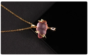Detail of pink resin cloud pendant with golden lightning and drop-shaped zircon stone