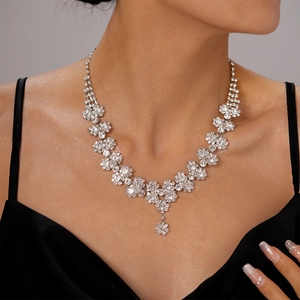 Close-up of a silver multi-layered necklace with sunflower diamond accents on a model