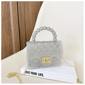Detail of silver glitter jelly bag with quilted pattern, pearl handle, and gold chain strap