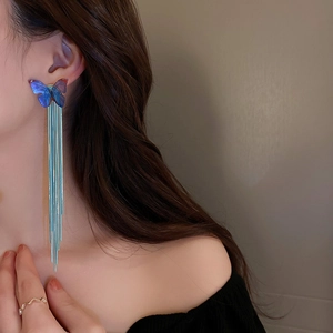 Detail of elegant butterfly tassel earrings featuring light blue translucent design and long fringe