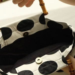Vintage polka dot pop-style handbag with bamboo handle and secure magnetic closure