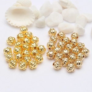 14k gold-filled pumpkin lantern beads for DIY jewelry with striped surface on white background