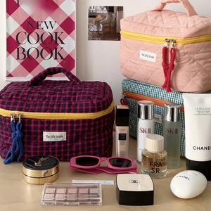 Quilted cosmetic bags in pink and blue plaid with yellow zippers and cord pulls
