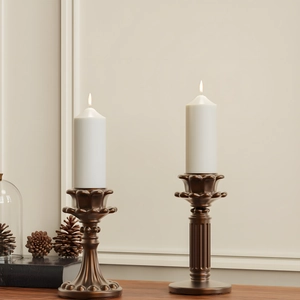 Details van vintage bronzen kandelaars met bloembladhouders en witte kaarsen