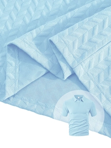 Détail macro du polo bleu ciel avec texture jacquard à chevrons et coutures précises