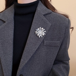 Elegant snowflake brooch with pearls and cubic zirconia on dark grey blazer lapel