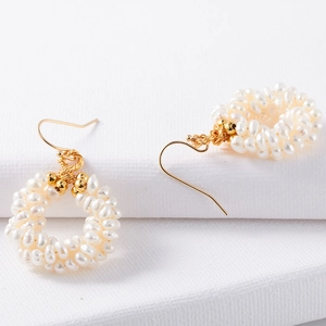 Macro shot of handmade woven fresh water pearl hoop earrings with gold plated hooks