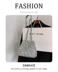 Detail of silver sequin bucket bag with metal chain strap on minimalist background