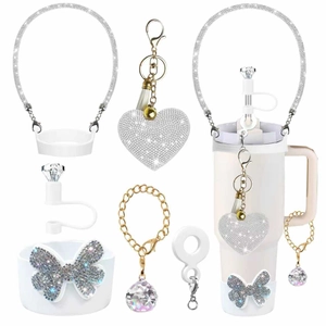 Close-up of sparkling rhinestone tumbler accessories with a crystal straw cover and handle strap