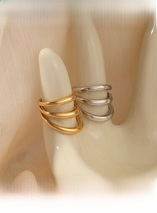 Polished gold and silver multi-layer rings shown on a hand model with silk background