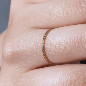 Macro shot of an ultra-thin 18K gold plated minimalist ring worn on finger