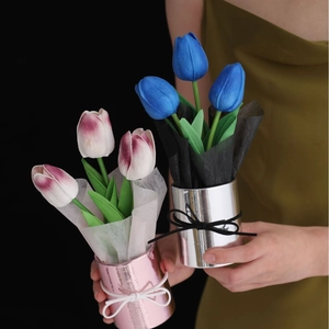 Close-up of handmade PU artificial tulip bouquets in metal pots held by hands