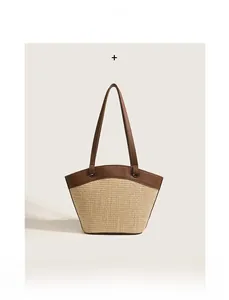 Detail of hand-woven straw and brown leather stitching on French retro tote bag