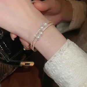 Bracelet double couche en or avec quatre perles et chaînes serties de cristaux