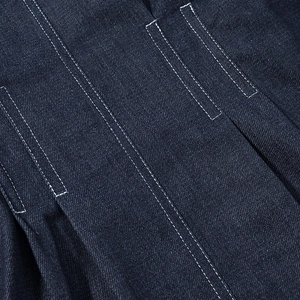Macro detail of dark blue denim fabric with white contrast stitching on a casual jacket