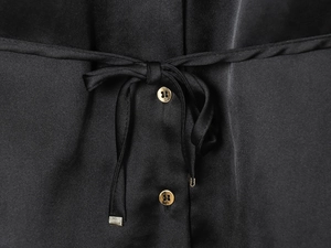 Dettagli camicia in raso nero con bottoni dorati e cintura con laccetto in vita