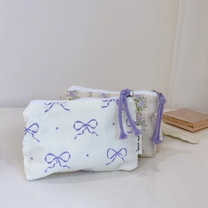 Detail of floral cotton pouches featuring rope zippers and delicate bow prints