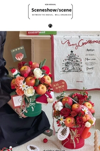 Close-up of Christmas gift box with fresh apples, roses, pine branches and festive ribbons